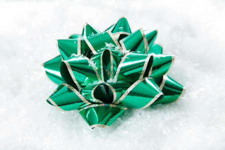 Christmas decorating bow in pile of snowflakesの写真素材