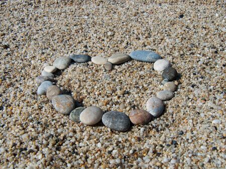 Small stones on a beach arranged in a shape of heartの写真素材