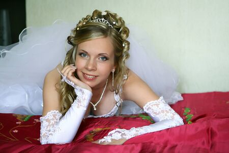 Young beautiful bride laying on the bedの写真素材