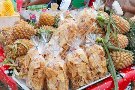 Banana chips and pineapples on outdoor fruit markeの写真素材