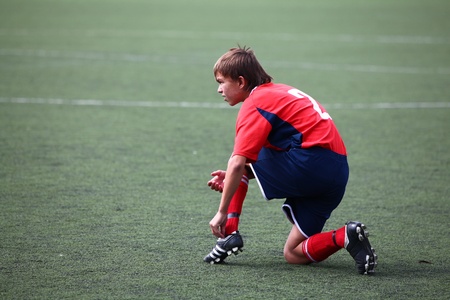 BELGOROD, RUSSIA - AUGUST 20  Unidentified boy fastening laces on boot on August, 20 2010 in Belgorod, Russia  The final of Chernozemje superiority, team of 1996 year of birth のeditorial素材