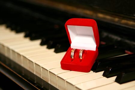 Wedding rings in red box on pianoの写真素材