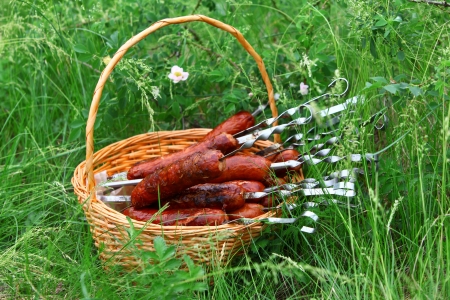 Roast sausages in the basket in the grassの写真素材