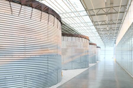 Row of metal tanks inside of industrial buildingの写真素材