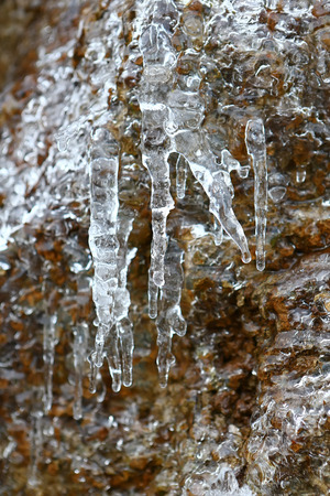 The thawing icicles with the falling water drop in the mountains of France in Vaujany in the winterの写真素材