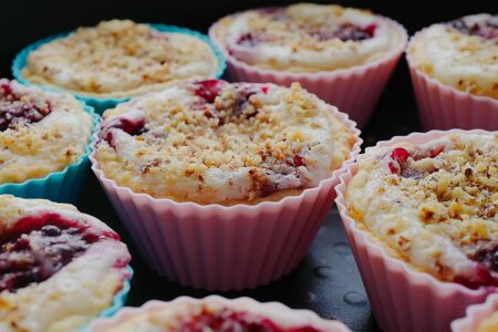 Tasty muffins with cream, berries and a nut crumb on round shapes の写真素材