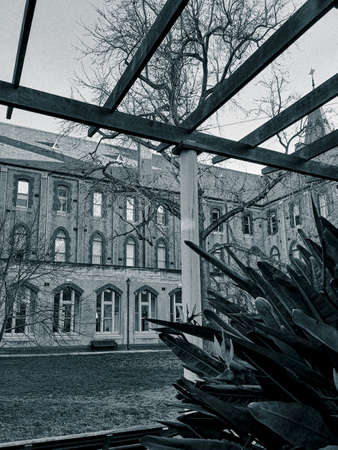 A black and white photograph of the exterior of an old school buildingの写真素材