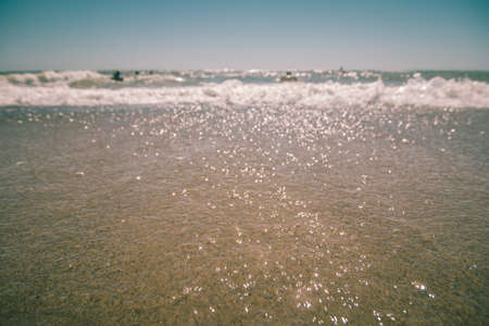 People swimming in the rough sea. View from the sandy beachの写真素材