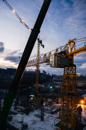 Construction site and cranes in the early evening. Workers on the crane and construction siteの写真素材