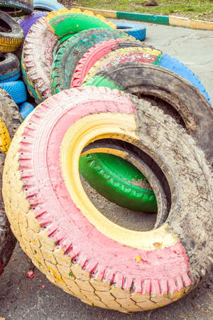 Pile of old multicolored car tires dug in playgrounds. Multicolor used tires. various sizes colored tires.の写真素材