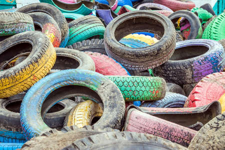 Pile of old multicolored car tires dug in playgrounds. Multicolor used tires. various sizes colored tires.の写真素材