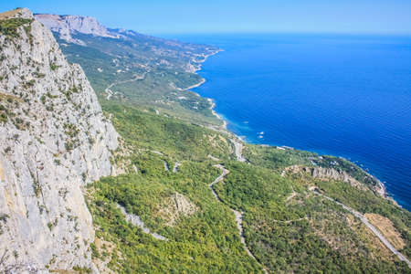 Mediterranean landscape. Forested rocks of the Black Sea coast of the southern coast of the Crimean Peninsula on a clear sunny day. View down from the rocky mountains to the seaの写真素材