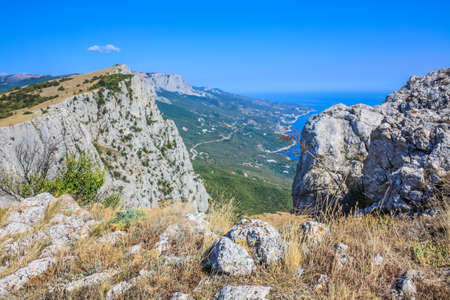 Mediterranean landscape. Forested rocks of the Black Sea coast of the southern coast of the Crimean Peninsula on a clear sunny day. View down from the rocky mountains to the seaの写真素材