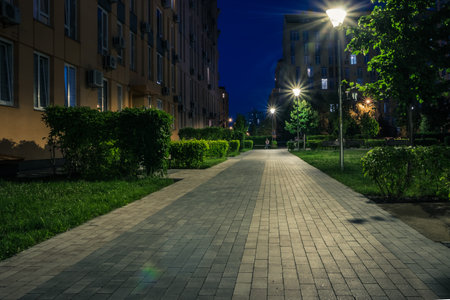 Night park paths and colored houses at summer night. Night paths, benches and lanterns in a beautiful residential complex. Night summer park with lanterns and benches. Kyiv. Ukraineの写真素材