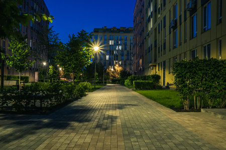 Night park paths and colored houses at summer night. Night paths, benches and lanterns in a beautiful residential complex. Night summer park with lanterns and benches. Kyiv. Ukraineの写真素材