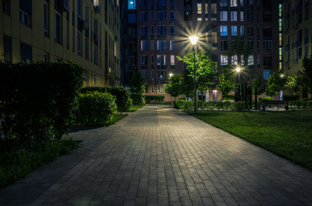 Night park paths and colored houses at summer night. Night paths, benches and lanterns in a beautiful residential complex. Night summer park with lanterns and benches. Kyiv. Ukraineの写真素材