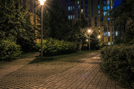 Night park paths and colored houses at summer night. Night paths, benches and lanterns in a beautiful residential complex. Night summer park with lanterns and benches. Kyiv. Ukraineの写真素材