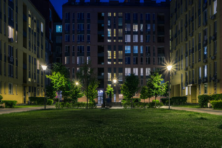 Night park paths and colored houses at summer night. Night paths, benches and lanterns in a beautiful residential complex. Night summer park with lanterns and benches. Kyiv. Ukraineの写真素材