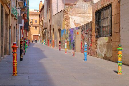 The picture was taken in Spain, in the ancient city of Tarragona. The picture shows surprisingly brightly colored street in the old district.の写真素材
