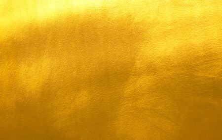 Shiny yellow leaf gold foil texture backgroundの写真素材