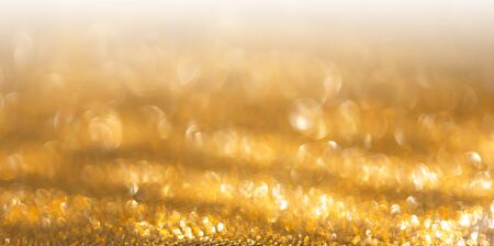 Gold Festive Christmas background. Abstract twinkled bright background with bokeh defocused golden...