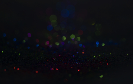 Bokeh glitter fly and lights on black backgroundの写真素材