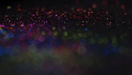 Bokeh glitter fly and lights on black backgroundの写真素材