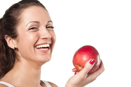 Studio shoot of smiling woman with red apple on a white backgroundの写真素材