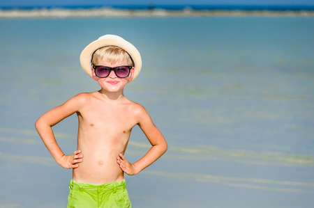 Portrait of a handsome seven years old boy on the desert sunny beachの写真素材
