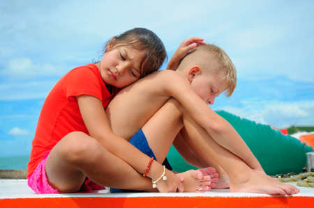 Comforting a friend. Young girl hugs her adorable boy.の写真素材