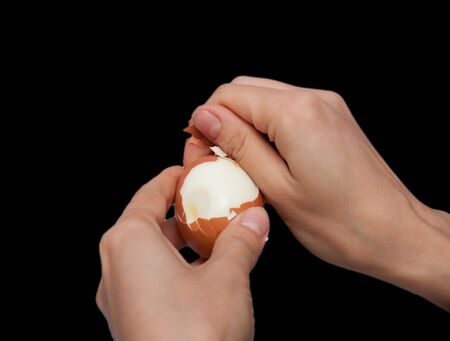 cleaning hands a boiled egg on a black backgroundの写真素材