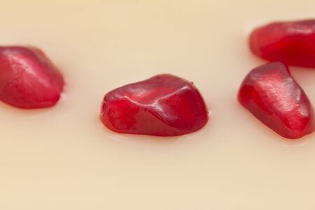 juicy ripe red pomegranate in milkの写真素材