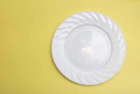 white plate on a yellow backgroundの写真素材