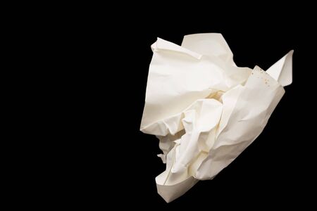 A crumpled paper ball in a black backgroundの写真素材