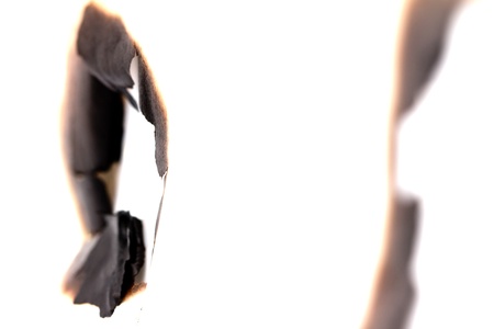 burned hole on a white paper backgroundの写真素材