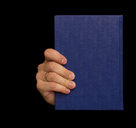 blue book in hand on a black backgroundの写真素材