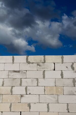 beautiful background of a brick wall and sky with cloudsの写真素材