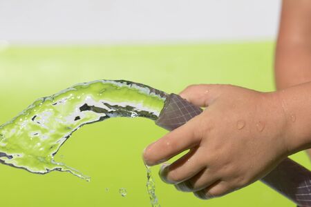 spray water from a hose child's handの写真素材