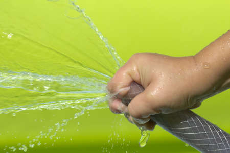 spray water from a hose child's handの写真素材