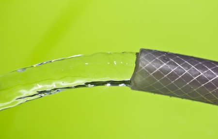 a jet of water from a hose on a green backgroundの写真素材