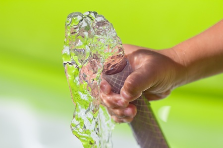 spray water from a hose child's handの写真素材