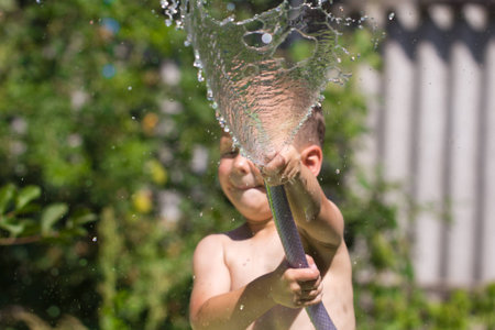boy squirting water from a hoseの写真素材