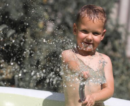 boy squirting water from a hoseの写真素材