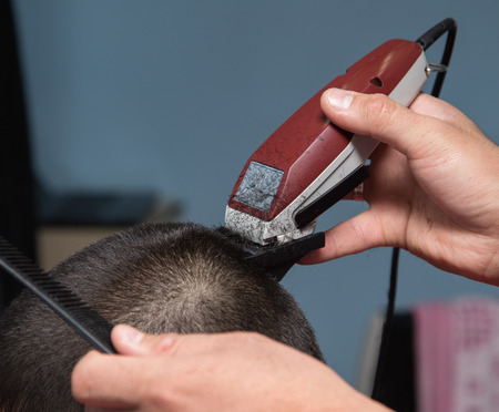 Men's haircut in the barber shop machine