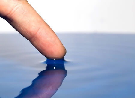 finger touches the water. macroの写真素材
