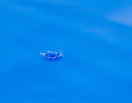 a drop of water falls in the blue. macro...の写真素材