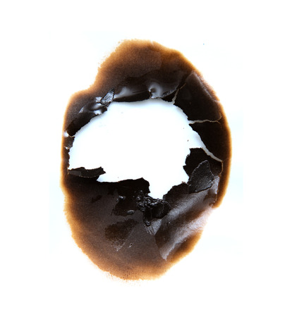 burned hole on a white paper backgroundの写真素材