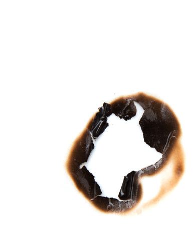 burned hole on a white paper backgroundの写真素材