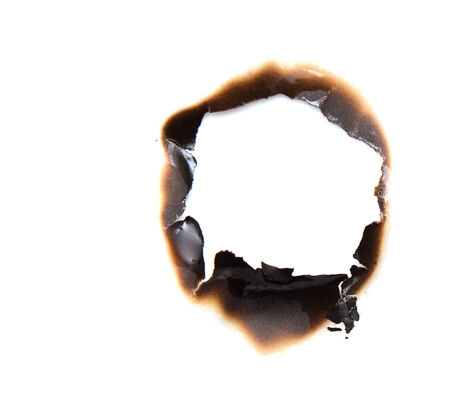 burned hole on a white paper backgroundの写真素材