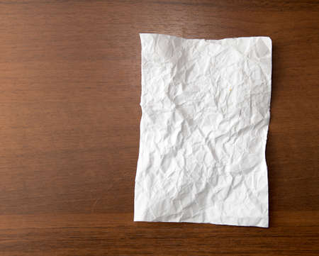 crumpled white paper on the wooden backgroundの写真素材